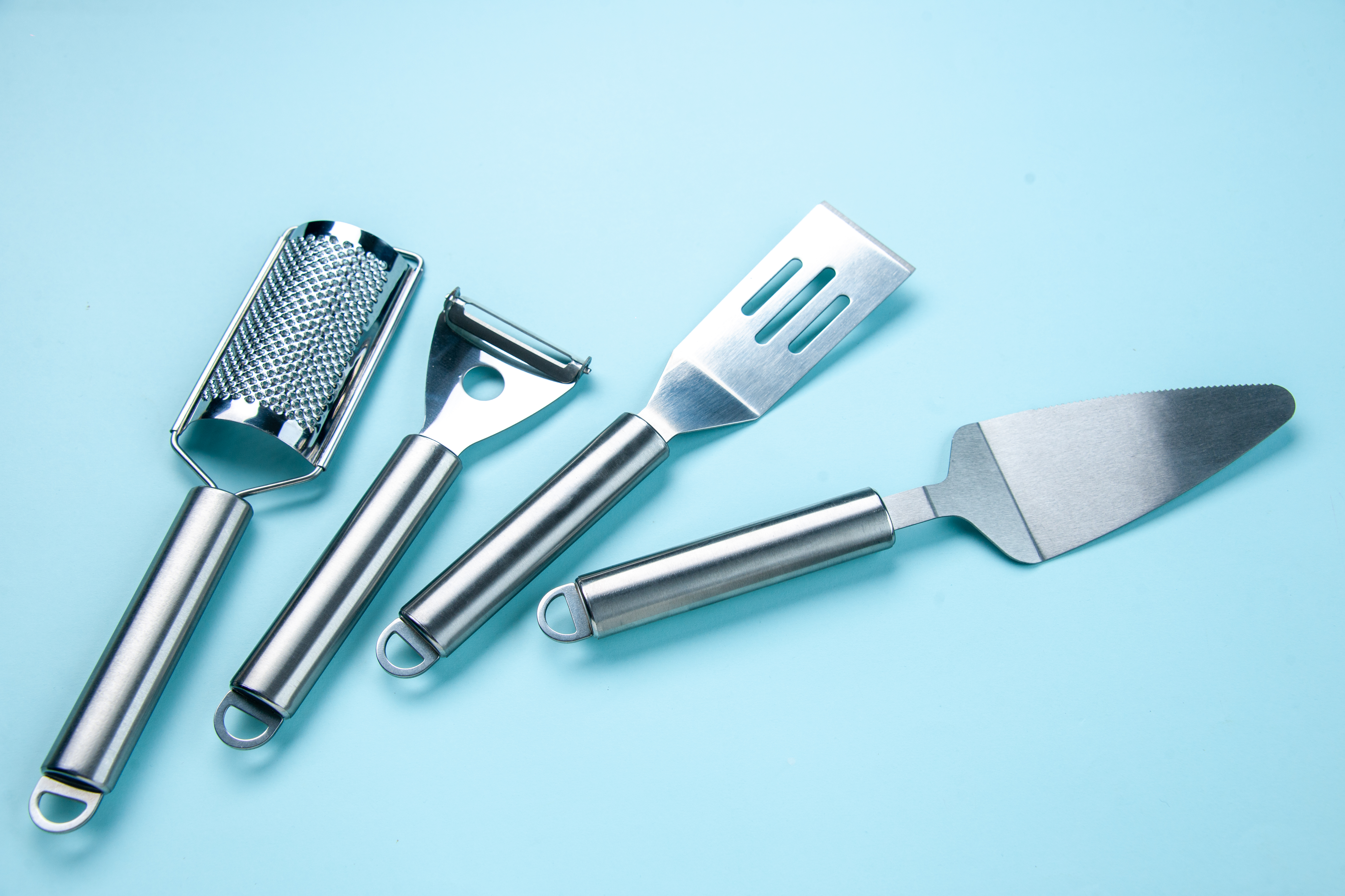 Above view of stainless kitchen tools on soft blue color background with free space